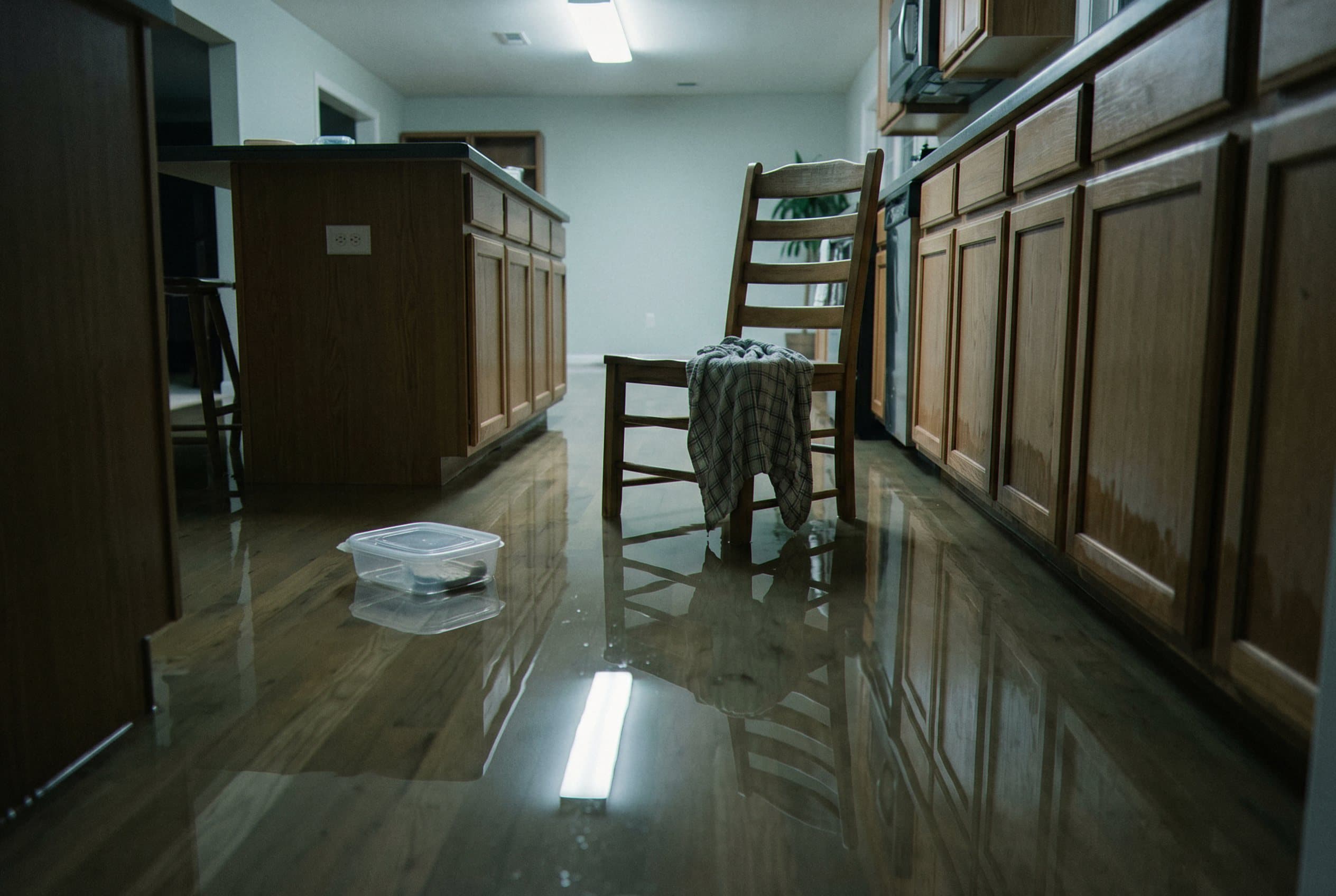 Wet basement floor with standing water and mud